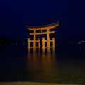 The Miyajima torii gate lit up at night.
